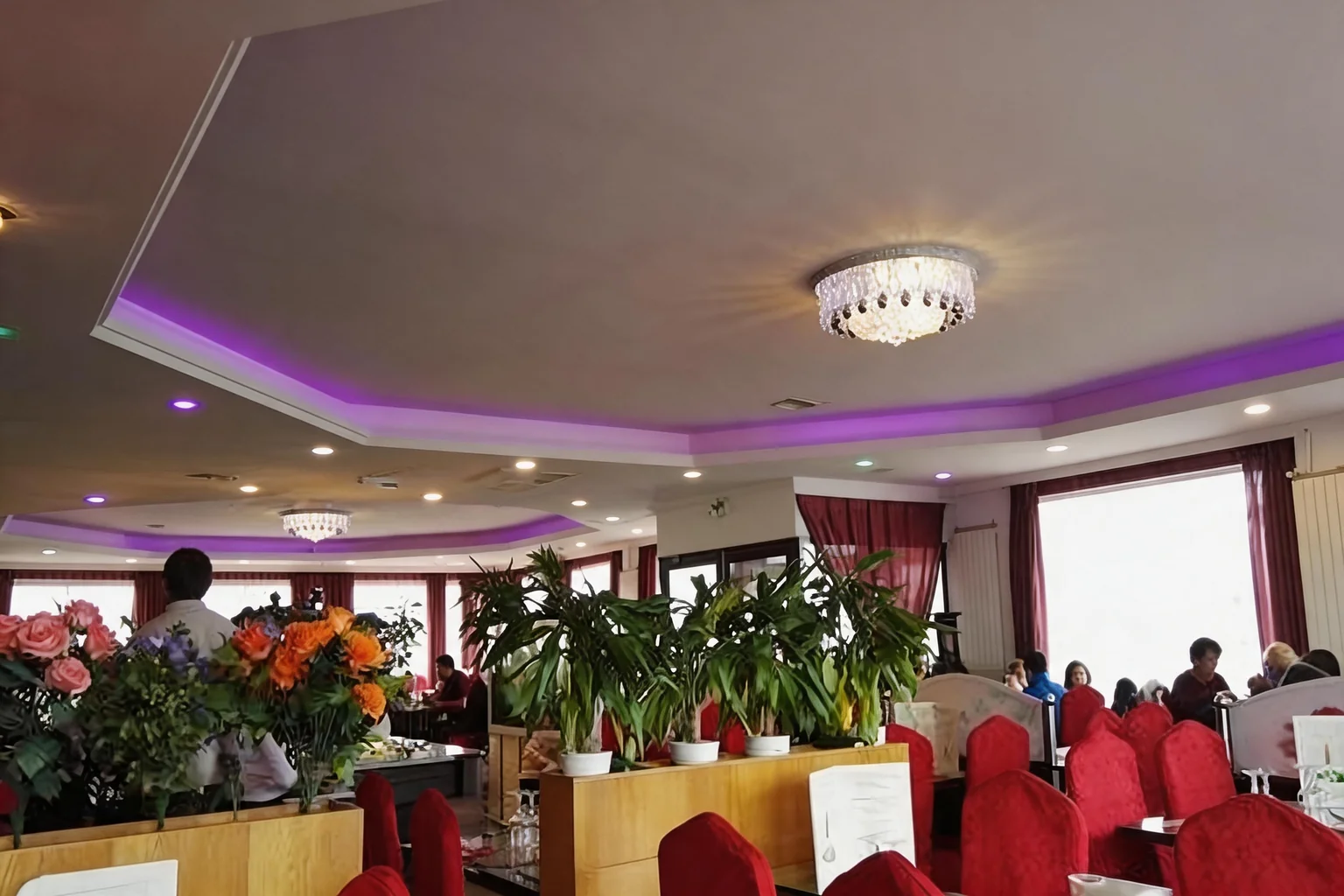The dining room, red chairs and soft purple lighting