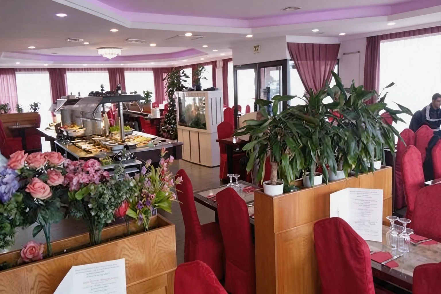 Dining room with set tables, red chairs and plants
