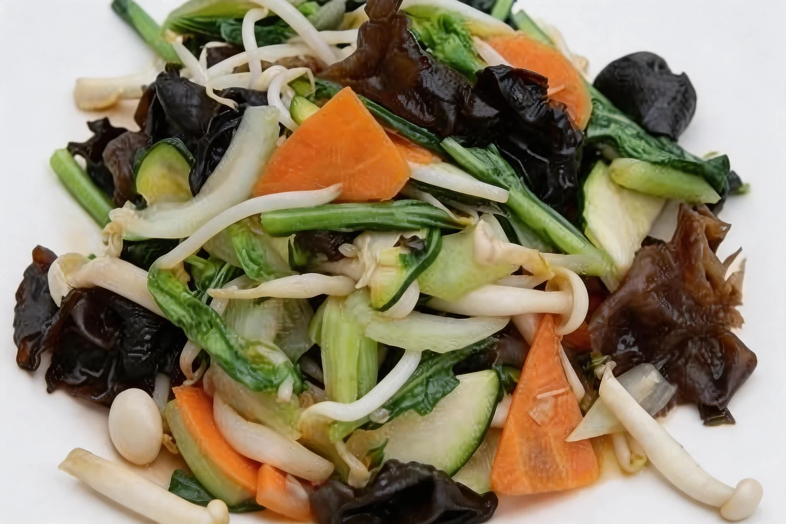 Chop suey vegetables on a white plate, with black fungus, carrot and sprouts